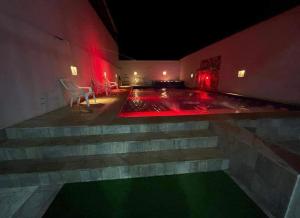 比列塔Hotel Tradicional Villeta的一间晚上设有游泳池的房间,配有红灯