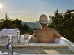 Grenville-sur-la-RougeÉco Spa Highland的坐在浴缸里戴帽子的人