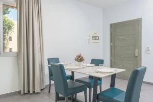 DbayehVibe 305, Modern 2Bedroom Apartment in Awkar的一间配备有白色桌子和蓝色椅子的用餐室