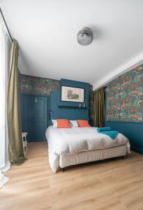 CussetGrande Maison Cusset - Maison de ville - 3 chambres的一间卧室拥有蓝色的墙壁,配有一张带橙色枕头的床。