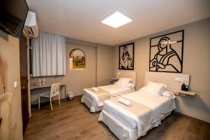 格拉纳达Hotel Monasterio Granada - Adults Only的一间医院间,配有两张床和电视