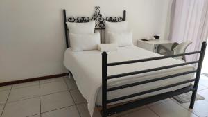 布隆方丹New Lodge的一间卧室配有带白色床单和枕头的床。