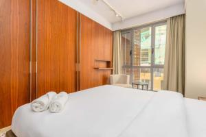 贝鲁特Violin 1 Bedroom Apartment in Solidere的卧室配有一张带2条毛巾的大型白色床