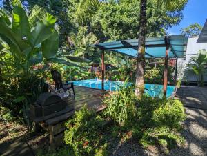 乌维塔Arboura Eco Cabins的花园内的游泳池,带蓝伞
