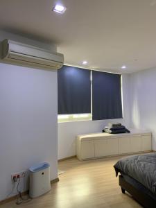 乔治市118 Apartment Tanjung Tokong by Yen's Sojourn的一间卧室配有一张床和一扇蓝色百叶窗