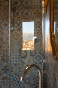 列蒂Orchidee apartment的浴室设有镜子和带水槽的淋浴
