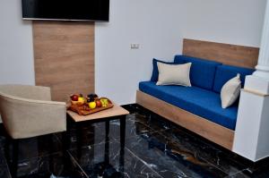 DjerbaHôtel Joya Paradise & SPA Djerba的一张蓝色的沙发,桌子上放着一碗水果