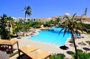 DjerbaHôtel Joya Paradise & SPA Djerba的度假村内带遮阳伞和棕榈树的游泳池