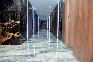 DjerbaHôtel Joya Paradise & SPA Djerba的一间铺有大理石地板并设有木墙的酒店走廊