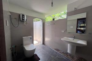 代尼耶耶辛哈拉加莱斯特旅馆的浴室配有白色卫生间和盥洗盆。