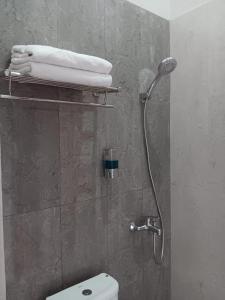 普禾加多44 Guest House Syariah的带淋浴、卫生间和毛巾的浴室