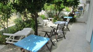 毕达哥利翁Sandalis Hotel的庭院配有桌椅和树木