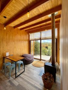 CalbucoTinyhouse Pichi I - vida lenta en Patagonia Costa的客厅配有桌子和壁炉