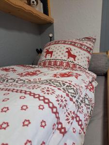 莱德萨阿尔卑斯STUDIO 2 ALPES STYLE CHALET au PIED DE TELESIEGE DU DIABLE的一张带鹿枕头的红色和白色棉被的床