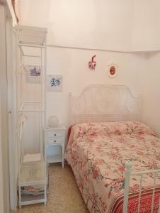 奥斯图尼La Casetta的白色卧室,配有床和白色架子