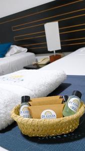 皮乌拉Di Costa Hotel的床上一篮子,上面装有两瓶洗涤剂