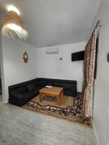KebiliDar Barka的客厅配有黑色沙发和桌子