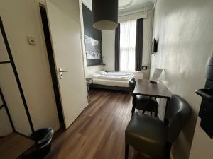 阿姆斯特丹Hotel Hortus的小房间设有一张桌子和一张床