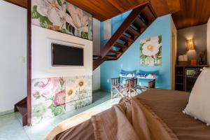 杰里科科拉Vila Charme的一间卧室配有一张床,墙上配有电视