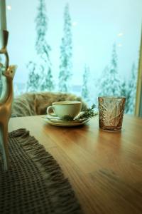 索特Villa Auroras Kettu的木桌上的杯子和盘子