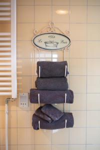 霍恩Hotel De Koegelwieck Terschelling的毛巾架,带四条毛巾和时钟
