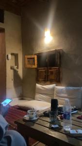 锡瓦Siwa desert home的一间客房配有一张床和一张桌子及一瓶水