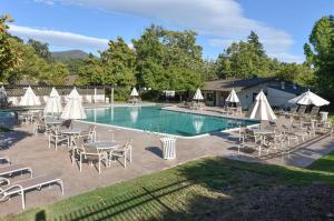 纳帕Getaway Suite at Silverado in Napa的一个带桌椅和白色遮阳伞的游泳池