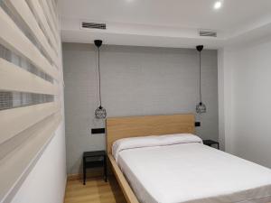 安度亚尔Fernando Quero 21的一间小卧室,配有一张床和两个吊灯