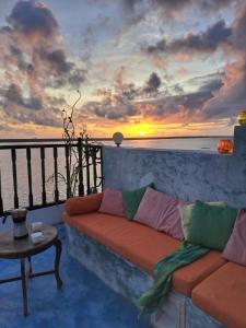 拉穆Pwani House - Lamu Seafront的带沙发和日落的客厅