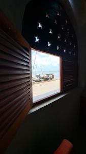 拉穆Pwani House - Lamu Seafront的客房设有可欣赏海滩景致的窗户。