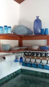 珀拉什奇亚Bella Vita Casitas的墙上有蓝色花瓶和碗的架子