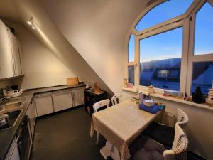 柏林One Private room available in a two room apartment in Tegel, Berlin的厨房配有桌子和2扇窗户。