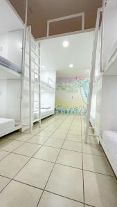 圣何塞SJO Oasis Hostel的一间设有白色双层床和壁画的房间
