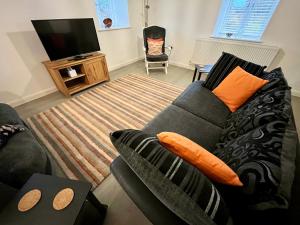 阿尼克29 Malthouse Alnwick Holiday Apartment的带沙发和平面电视的客厅