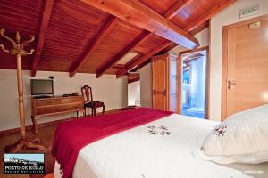 利洛Porto de Rinlo的一间卧室配有一张床和一张书桌及电视