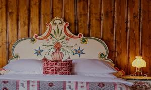 耶塞尼克十字山酒店的一间卧室配有一张带花卉床头板的床