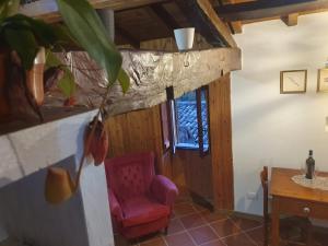 波焦莫亚诺Casa Puggimiano的客厅配有红色椅子和桌子