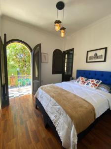 圣地亚哥Hostal El Raco的一间卧室配有一张蓝色床头板的大床