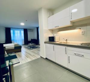 艾格扎洛克M&F Apartman的一间带白色橱柜的厨房和一间客厅