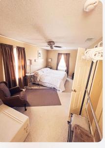 奥尔巴尼Rose Ellen’s Country Estate的一间卧室配有一张床和一把椅子
