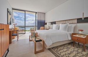 La RiberaFour Seasons Resort Los Cabos的一间卧室配有一张大床、一张桌子和一张书桌