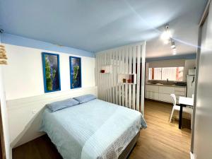 弗洛里亚诺波利斯Pousada Ilha do Campeche的一间卧室配有一张床,厨房配有桌子