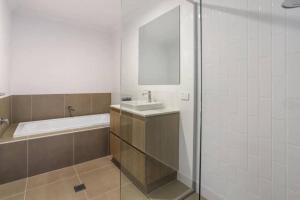 NarellanBrand New Home In Oran Park的浴室配有盥洗盆和浴缸。
