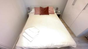 蒙特卡罗Super Monaco的一间小卧室,配有白色的床和两个枕头