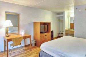 威廉斯维尔莫特尔6号布法罗机场汽车旅馆的一间卧室配有一张床和一张书桌及电视