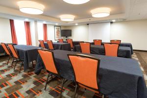 乔普林乔普林德鲁里套房酒店的会议室配有黑色桌子和橙色椅子