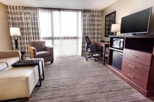 堪萨斯城德鲁里套房酒店堪萨斯城机场店的酒店客房设有一张沙发和一张带电视的书桌。