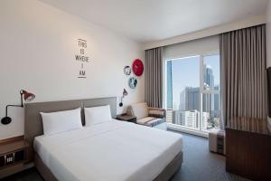 迪拜迪拜贸易中心罗弗酒店的酒店客房设有一张床和一个大窗户
