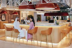 迪拜Rove Expo City的一间两人坐在酒吧的餐厅