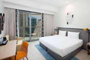 迪拜Rove Expo City的卧室配有一张白色大床、一张书桌和窗户。